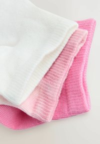 Tre par sokker: en hvid, en lys pink og en mørkere pink. Ribbet tekstur med forstærkede manchetter i blødt bomuldsstof.