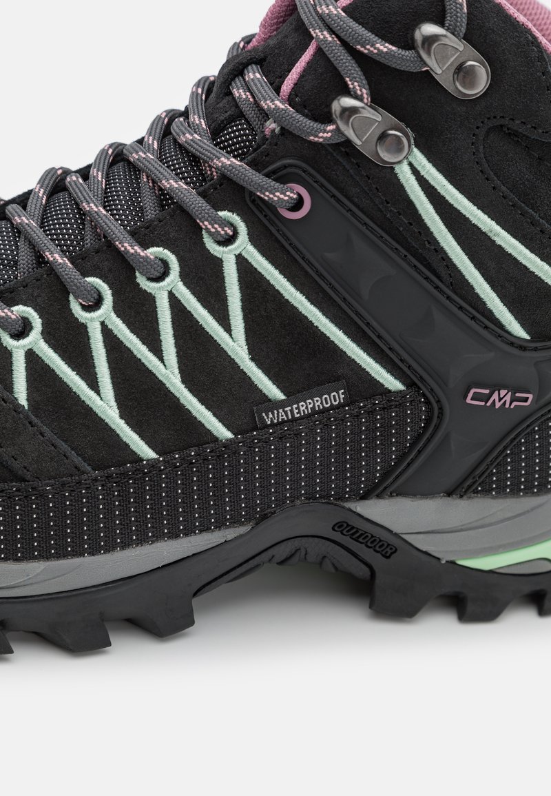 Botas de senderismo negras con acentos en gris y menta, material impermeable, ante texturizado y suela de goma robusta. Presenta ojales metálicos y cordones.
