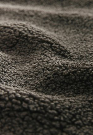 Dunkelgrauer, strukturierter Stoff mit einer weichen, flauschigen Oberfläche, der ein wellenförmiges Muster und ein plüschiges Aussehen aufweist, geeignet für Wärme und Komfort.