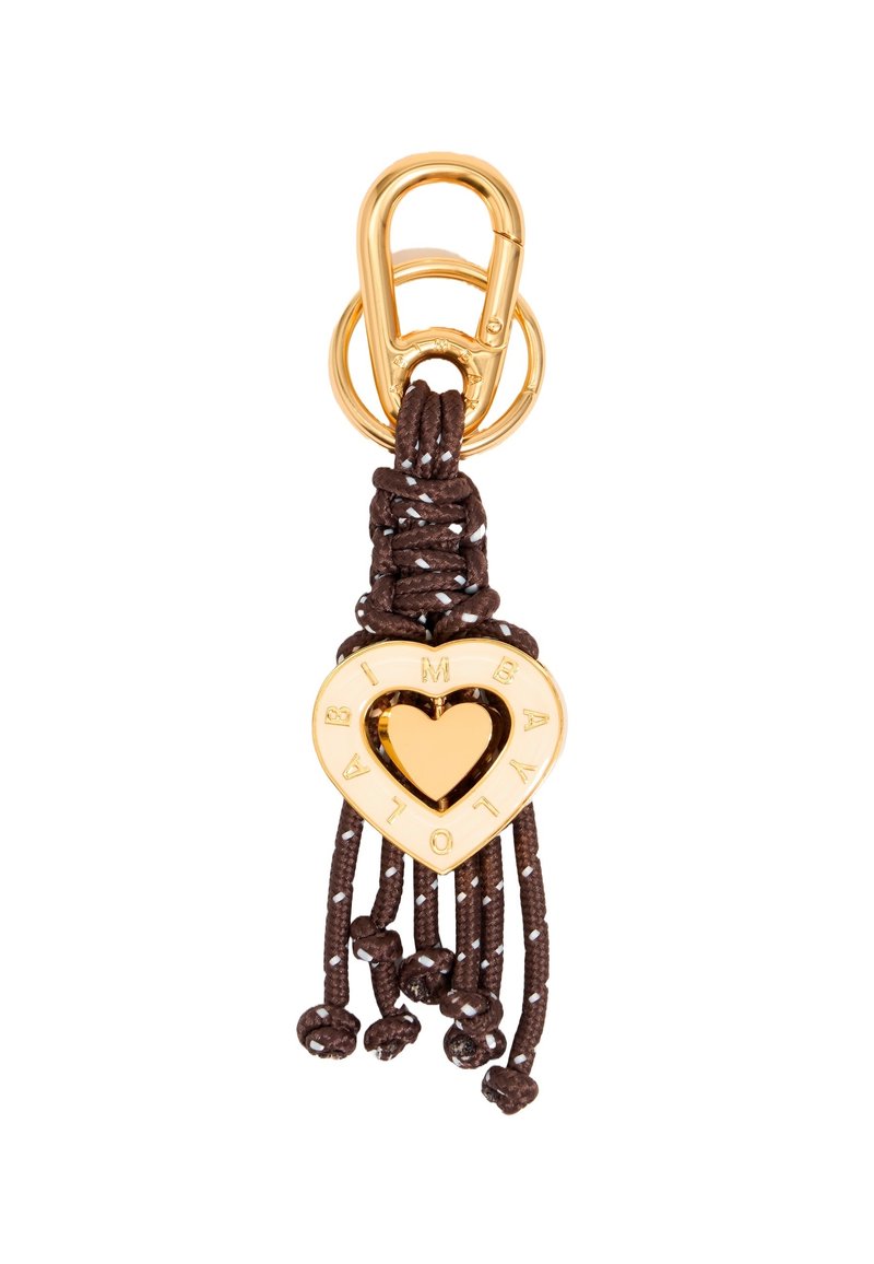 Gold heart-shaped charm with cutout center and engraved letters, attached to brown braided cord and loop, featuring tassel ends and beads.