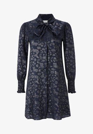 Navy dress with a leopard print in silver, featuring a bow tie collar and long, smocked sleeves. Smooth, shiny fabric with a structured shape.
