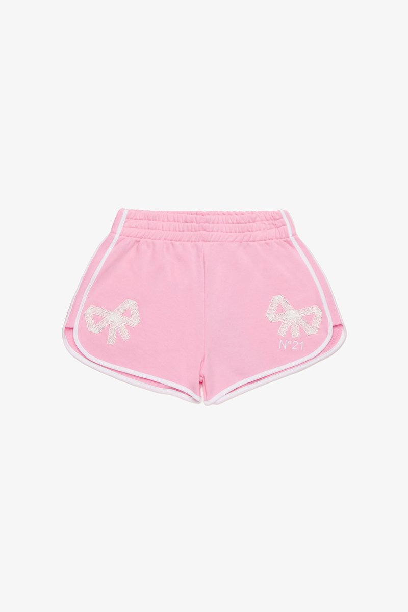 Ružové bavlnené šortky s bielym bočným lemovaním a aplikačnými prvkami v tvare mašlí na vreckách. Majú elastický pás pre pohodlie. Vyšívané logo v bielej farbe.