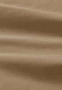 Tessuto color terra con una texture morbida e liscia, caratterizzato da leggere pieghe che creano un aspetto drappeggiato. Il materiale ha una finitura opaca senza motivi.