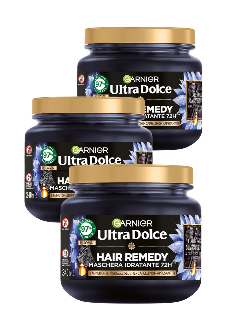 Tre barattoli blu scuro con coperchi dorati etichettati "Garnier Ultra Dolce Hair Remedy", caratterizzati da un design floreale e un badge verde che indica il 97% di ingredienti naturali.