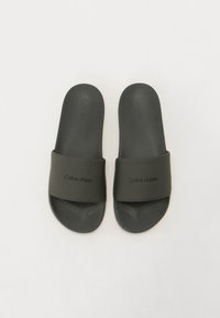 Črne pohodne sandale z širokim mat trakom z vtisnjenim logotipom "Calvin Klein", oblazinjenim podplatom in teksturiranim podplatom.