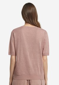 Kortärmad tröja med rund hals i mjukt, ljusrosa tyg. Har en ribbad kant i nederkant och ärmslut, med slät yta genom hela plagget.