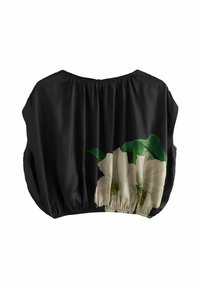 Blouse noire à coupe ample, avec un ourlet élastique froncé. Décorée d'un grand imprimé floral blanc et de feuilles vertes sur le devant.