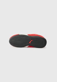 Baskets en daim rouge avec semelle en caoutchouc noir. Présentent un accent blanc et un motif de semelle texturé pour l'adhérence. Logo rouge sur la semelle.