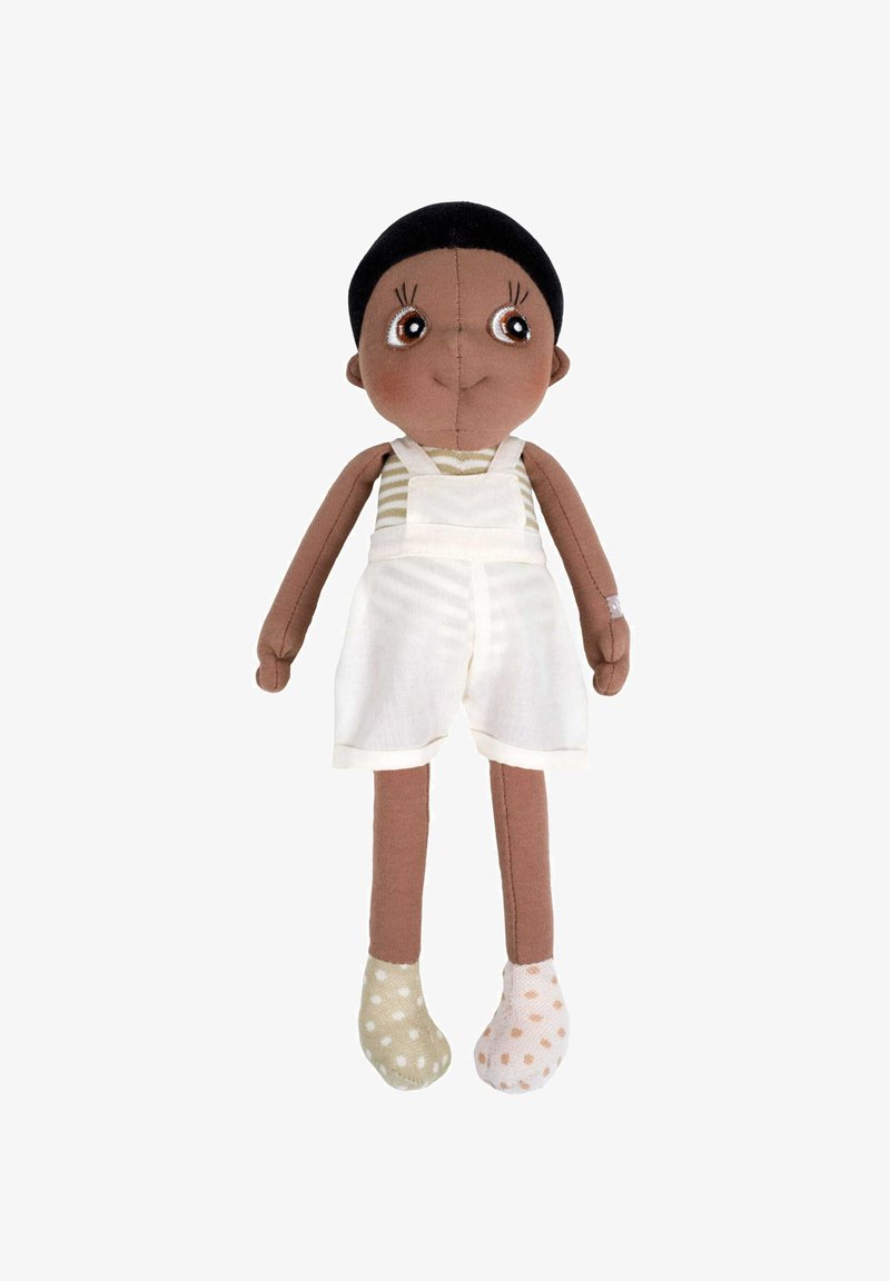 Miękka lalka z brązową skórą, czarnymi włosami i dużymi brązowymi oczami. Ubrana w białe ogrodniczki na paskowanej koszulce, nosi niepasujące skarpetki w kropki.