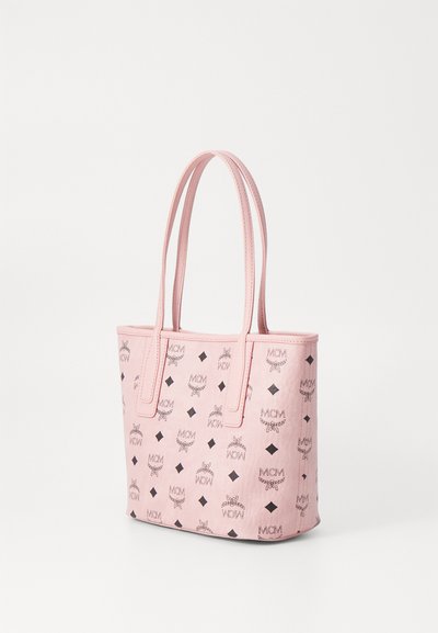 Geantă tote roz cu o suprafață texturată, având logo-uri MCM negre și modele cu diamante, cu mânere duale și un design deschis în partea de sus.