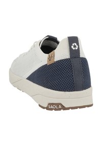 Bílé a námořnické tenisky s texturovaným síťovaným svrškem, korkovým akcentem na patě a gumovou podrážkou s logem na zadní straně.