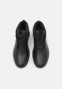 Zapatos de cuero negro con diseño de caña alta, cordones resistentes, cuellos acolchados y detalles en gris contrastante en la parte superior.