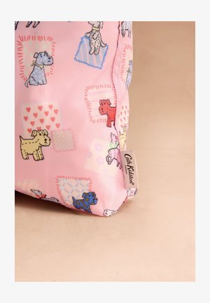 Rožnata tkanina z barvitimi risanimi psi in vzorci patchwork, na strani je bela etiketa Cath Kidston London.