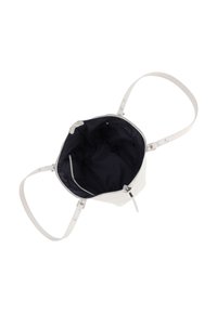 Bolso blanco con correas ajustables, sin cerrar, que muestra un amplio interior negro y pequeños bolsillos interiores.