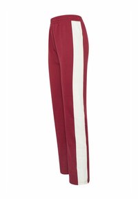 Pantalons de survêtement bordeaux avec une bande latérale blanche, équipés d'une taille élastique, d'une coupe droite et d'une texture de tissu douce.