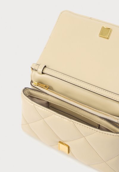 Beige quilted leather bag with a gold square clasp, featuring an unzipped interior and a zippered compartment. Soft texture and structured design.