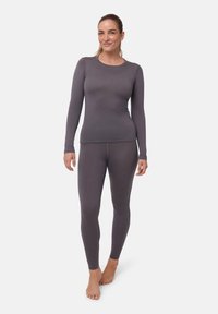 Grå termotröja och leggings gjorda av ribbat tyg. Långa ärmar, tight passform, mjuk textur och sömlös konstruktion för komfort.