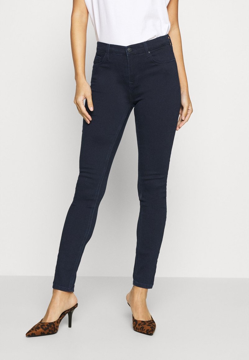 Mörkblå smala jeans med medelhög midja, femficksdesign och diskret sömnad. Matcher med bruna klackar i leopardmönster.