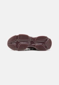 Semelle de chaussure en caoutchouc bordeaux avec un motif texturé en zigzag pour une traction optimale et une finition lisse, mettant en valeur ses bords arrondis et sa construction.