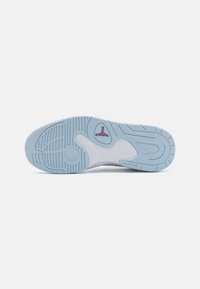 Modrá gumová podrážka tenisky s texturovanými vzory, zahrnující bílou středovou část a malý růžový logo detail poblíž paty.