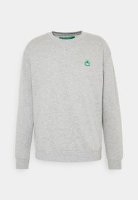 Grå crewneck-tröja gjord av bomullsblandning. Har en liten grön logotyp på vänster bröst och ribbade muddar och nederkant.