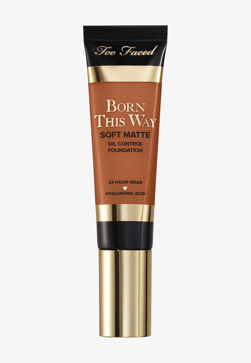 Too Faced Born This Way Soft Matte Oil Control Foundation in einer Tube mit Quetschverschluss. Brauner Körper mit goldenen und schwarzen Akzenten; cremefarbener Boden.