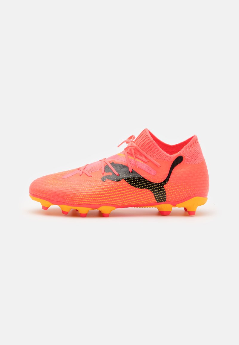 Scarpe da calcio rosa brillante con tomaia testurizzata, marchio nero e tacchetti gialli. Presentano un colletto lavorato a maglia e un design con lacci.