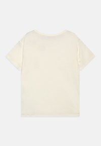 Camiseta de manga corta color crema hecha de algodón suave. Diseño sencillo con cuello redondo y dobladillo recto, sin patrones ni acentos visibles.