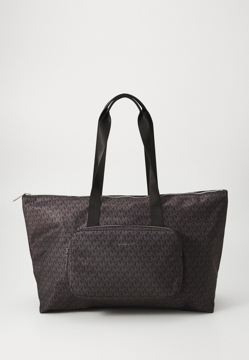 Grand sac fourre-tout gris foncé avec un motif géométrique, doté de deux poignées noires et d'une poche zipée à l'avant. Accents en métal argenté.