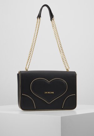 Borsa a mano in pelle nera con tracolle a catena dorate, dettagli con borchie dorate e design a cuore intorno al logo Love Moschino sul davanti.