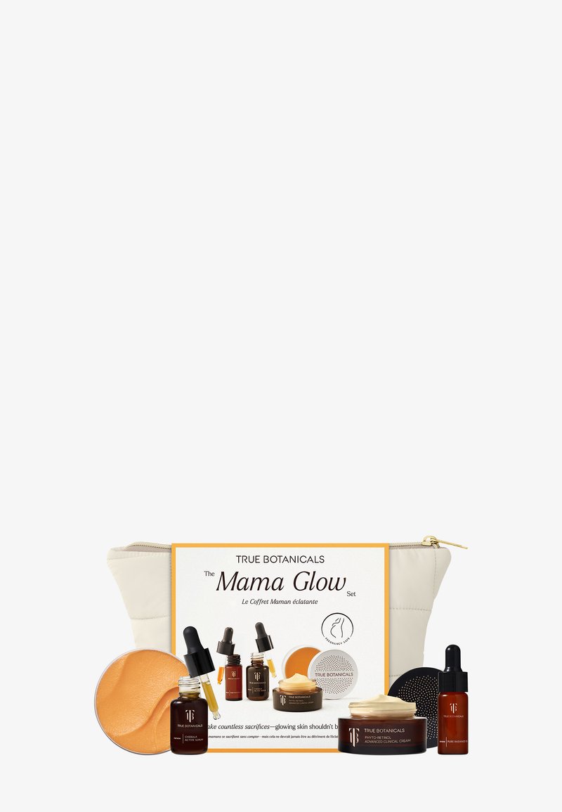 Das Set umfasst eine Creme und Öle in amberfarbenen Glasflaschen, einen gelben Balsam und einen goldakzentuierten Beutel. Es zeichnet sich durch neutrale Farben und verschiedene Texturen aus.