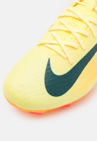 Kollane jalgpallijalatse tekstuuriga ülemise osaga, rohelise Swoosh logo ja erksate oranžide nippudega. Omab kergeid materjale ja nähtavat paeltesüsteemi.