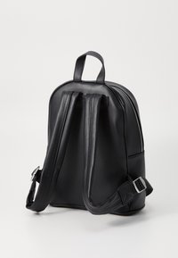 Zaino in pelle sintetica nera con spallacci regolabili, manico superiore e dettagli in zip argentati. Presenta un design liscio e a sgargianti.