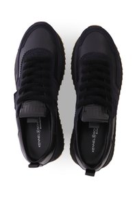 Schwarze Sneaker aus einer Kombination von Leder und Wildleder, mit runder Kappe, strukturierten Schnürsenkeln und gerillter Gummisohle. Mit einem Anziehschlitz an der Ferse.