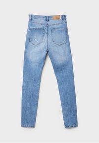 Ljusblå denimjeans med slim fit, femfickdesign och synlig sömnad. Har en brun läderlapp vid midjan.