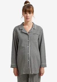 Black and white gingham-patterned pajama set with a button-up design, chest pocket, and contrasting piping on cuffed sleeves.