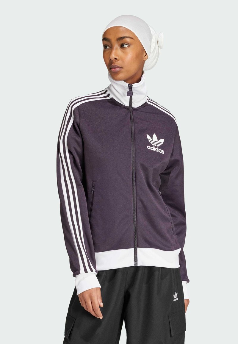Chaqueta de chándal Adidas en color morado oscuro con detalles en blanco, con cremallera frontal, cuello alto y tres rayas blancas en cada manga.