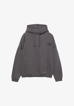 Szary, oversize sweatshirt z kapturem, kieszenią kangurką i sznurkami do ściągania. Zawiera czarny nadruk tekstowy na lewej stronie klatki piersiowej. Miękki w dotyku materiał.
