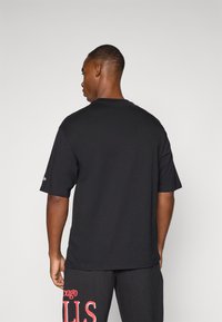 Sort kortærmet t-shirt med rund hals. Glat stof med en afslappet pasform. Ingen synlige grafik eller mønstre. Simpelt design.