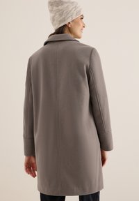 Manteau en laine gris avec un col et de longues manches, présentant une texture lisse et un design épuré. Montre la vue arrière avec une coupe droite.