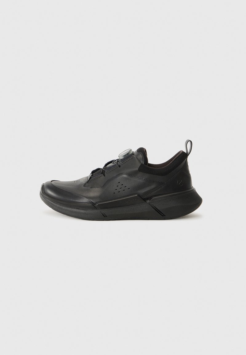 Black athletic shoe with a streamlined design, featuring a textured upper, mesh accents, a pull tab, and a lace-free closure system.