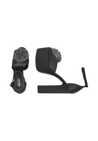 Černé sandály na vysokém podpatku s texturovanou platformou a akcentem v podobě květiny z kamínků na pásce přes špičku. Součástí je nastavitelné zapínání kolem kotníku.