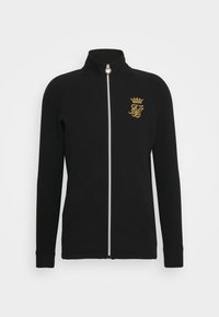 Giacca nera con zip e collo alto, realizzata in tessuto morbido. Presenta un logo ricamato in oro con una corona e dettagli della cerniera in argento.