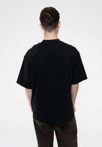 Black short-sleeve t-shirt with a relaxed fit, round neck, and soft cotton material. No visible patterns or graphics.