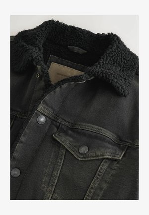 Zwarte denimjas met een fluffy zwarte kraag, met knoopsluitingen, borstzakken en een gestructureerde afwerking. Etiket zichtbaar binnenin de kraag.