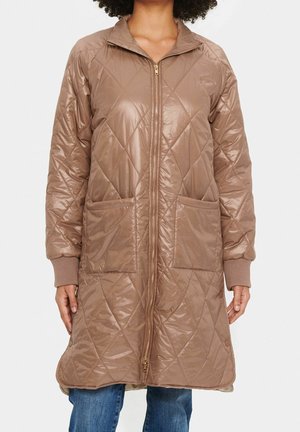 Manteau long matelassé marron clair avec une fermeture éclair à l'avant, deux grandes poches et des poignets côtelés. Texture lisse et brillante avec un motif en diamant.