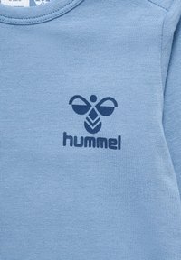 Lichtblauwe sweatshirt met een marineblauw logoontwerp met een bijen- en loofmotief. Zachte textuur en ronde halslijn.
