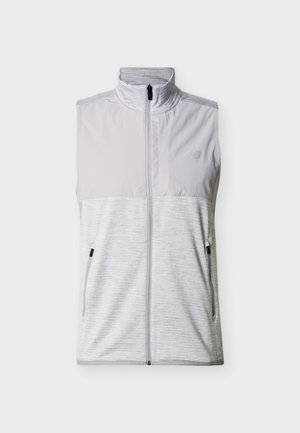 Svetlo siva brezrokavnik z zadrgo, z visokim ovratnikom, dvema žepoma z zadrgo na straneh in subtilnim logotipom na zgornjem levem delu prsnega koša.