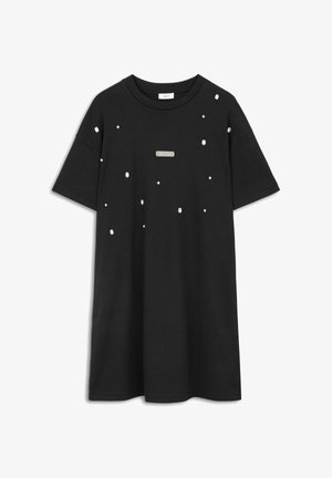 Zwarte T-shirt met korte mouwen en een losse pasvorm, voorzien van verspreide witte versieringen en een rechthoekig metalen label aan de voorkant.