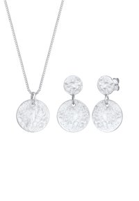 Set di gioielli in tonalità argento composto da una collana con pendente circolare testurizzato e orecchini a bottone rotondi abbinati. La catena ha un design a maglie piatte.